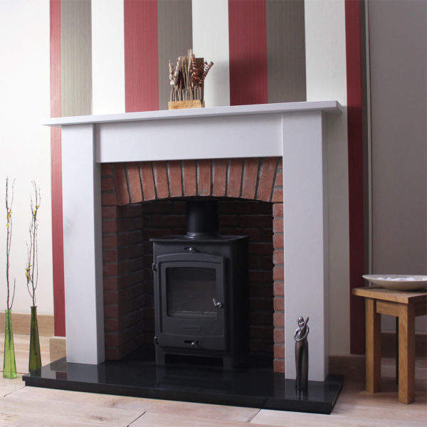 Oxford marble fireplace shown in a Spanish Blanco Micro marble shown with a stove and brick chamber